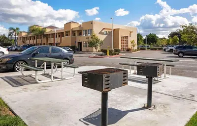 a parking lot with a picnic table and benches at Extended Stay America Suites - Orange County - Irvine Spectrum in Irvine