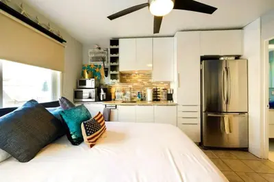 a kitchen with a bed with pillows and a refrigerator at 107-Oceanfront Lux 17 in San Diego