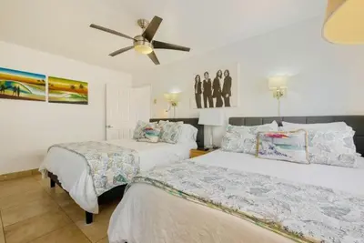 a bedroom with two beds and a ceiling fan at 107-Oceanfront Lux 17 in San Diego
