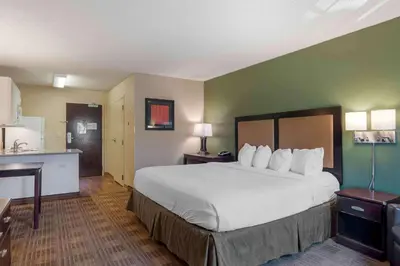 a hotel room with a large bed and a kitchen at Extended Stay America Suites - Orange County - Lake Forest in Foothill Ranch