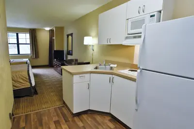 a kitchen with a white refrigerator and a room at Extended Stay America Suites - Orange County - Lake Forest in Foothill Ranch