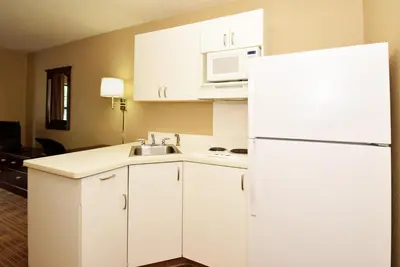 a kitchen with white cabinets and a white refrigerator at Extended Stay America Suites - Orange County - Lake Forest in Foothill Ranch