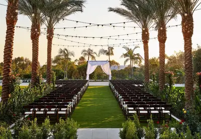 an aisle with chairs and a marquee with palm trees at Park Hyatt Aviara in Carlsbad