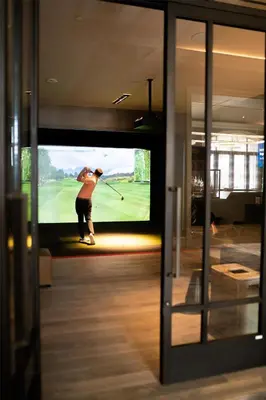 a man is playing golf on a television screen at Park Hyatt Aviara in Carlsbad
