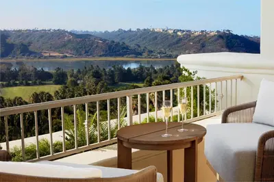 a balcony with a table and chairs and a view of a lake at Park Hyatt Aviara in Carlsbad