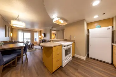 a kitchen with a white refrigerator and a table at Capistrano SurfSide Inn in Capistrano Beach