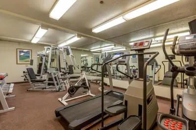 a gym with several treadmills and machines in it at Capistrano SurfSide Inn in Capistrano Beach