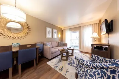 a living room with a couch and a dining room at Capistrano SurfSide Inn in Capistrano Beach