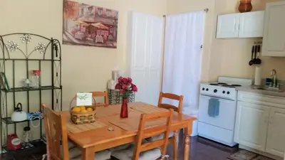 a kitchen with a table with a vase of flowers on it at Castlegate Guest Apartment in Vista