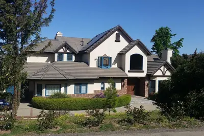 a white house with a black roof at Castlegate Guest Apartment in Vista