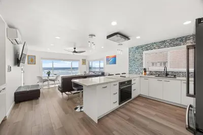 a kitchen with white cabinets and a table and chairs at 103-Luxury3 in San Diego