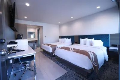 a hotel room with two beds and a desk at Rodeway Inn San Clemente in San Clemente