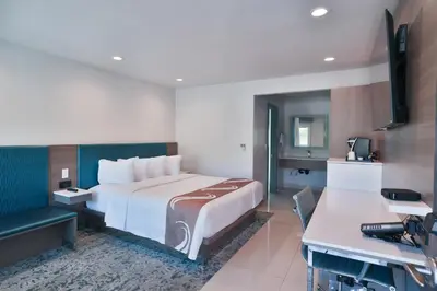 a hotel room with a large bed and a bathroom at Rodeway Inn San Clemente in San Clemente
