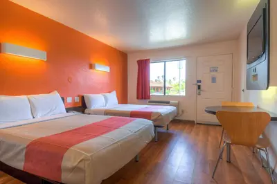 a hotel room with two beds and a television at Motel 6-Chula Vista, CA - San Diego in Chula Vista