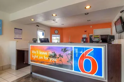 a waiting room with a sign on a tv at Motel 6-Chula Vista, CA - San Diego in Chula Vista