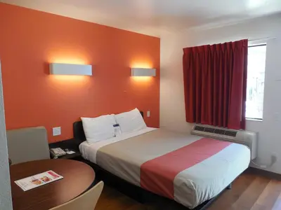 a small hotel room with a bed and a table at Motel 6-Chula Vista, CA - San Diego in Chula Vista