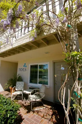 a patio with two chairs and a porch with a balcony at The Tides Laguna Beach in Laguna Beach