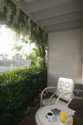 a chair sitting on a porch with a table and drinks at The Tides Laguna Beach in Laguna Beach