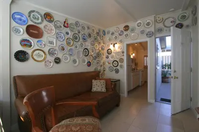 a living room with a couch and plates on the wall at The Tides Laguna Beach in Laguna Beach