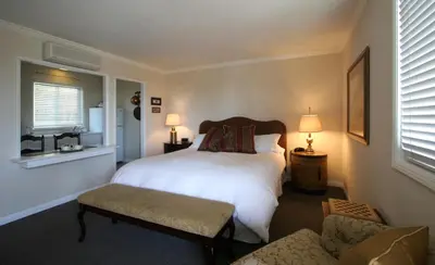 a bedroom with a white bed and a chair at The Tides Laguna Beach in Laguna Beach