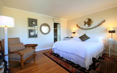 a bedroom with a white bed and a chair at The Tides Laguna Beach in Laguna Beach
