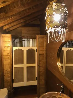 a bathroom with a mirror and a chandelier at Wine Country Private Working Sheep Farm; Rustic Elegance in Temecula