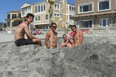 a group of men sitting in the sand on the beach at 108-Ocean Front Combo in San Diego