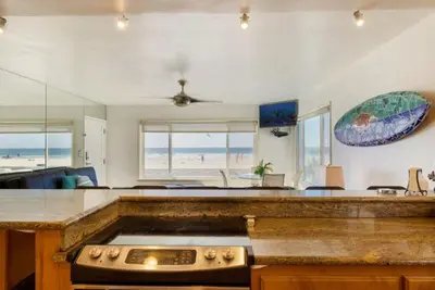 a kitchen with a counter top with a view of the beach at 108-Ocean Front Combo in San Diego