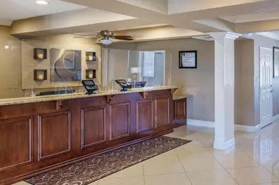 a large kitchen with a bar with a mirror at Comfort Suites San Clemente Beach in San Clemente