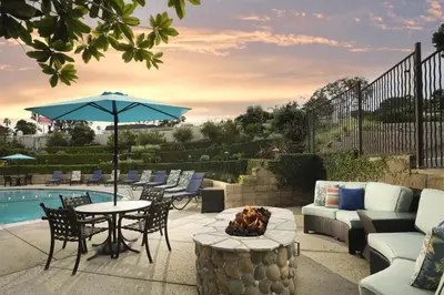 a patio with a table and chairs and a fire pit at Best Western Premier Hotel Del Mar in San Diego