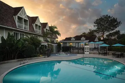 a swimming pool in front of a house at Best Western Premier Hotel Del Mar in San Diego