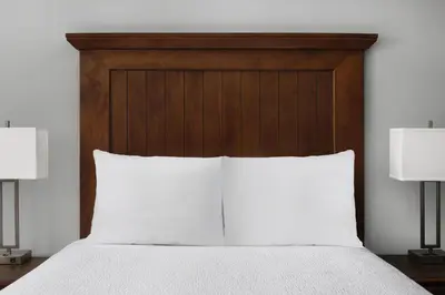 a bed with a wooden headboard and two lamps at Best Western Premier Hotel Del Mar in San Diego