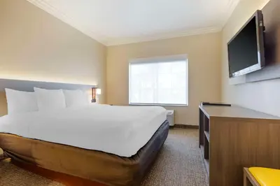 a hotel room with a bed and a flat screen tv at Comfort Suites Oceanside Camp Pendleton Area in Oceanside