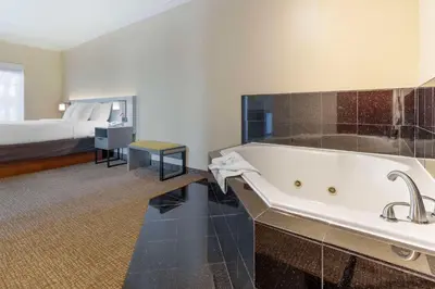 a large bathroom with a tub and a bed at Comfort Suites Oceanside Camp Pendleton Area in Oceanside