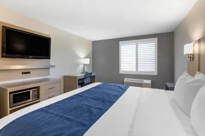 a bedroom with a large bed and a flat screen tv at Comfort Inn San Diego Miramar in Miramar