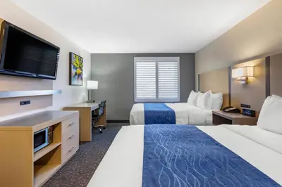a hotel room with two beds and a flat screen tv at Comfort Inn San Diego Miramar in Miramar