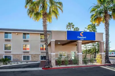 a hotel with palm trees in front of a building at Comfort Inn San Diego Miramar in Miramar