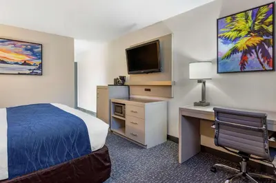 a hotel room with a bed and a desk and a tv at Comfort Inn San Diego Miramar in Miramar