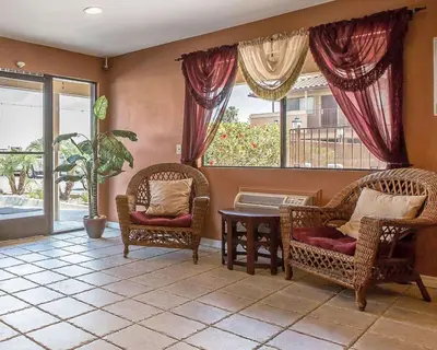 a living room with two chairs and a table and a window at Rodeway Inn Santee San Diego East in Santee