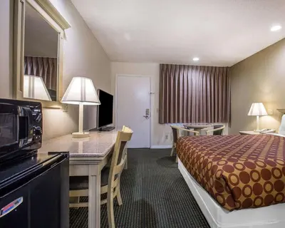 a hotel room with a bed and a table and a kitchen at Rodeway Inn Santee San Diego East in Santee