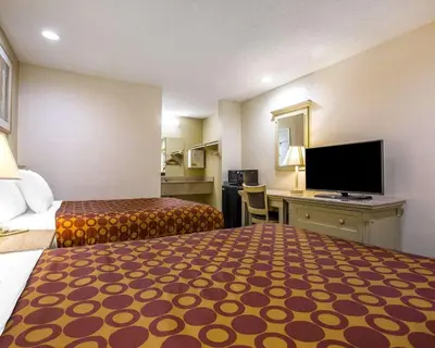 a hotel room with two beds and a flat screen tv at Rodeway Inn Santee San Diego East in Santee