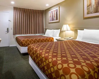 a hotel room with two beds and a bathroom at Rodeway Inn Santee San Diego East in Santee
