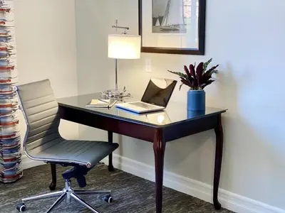 a desk with a laptop and a chair in a room at Ayres Suites Mission Viejo - Lake Forest in Mission Viejo