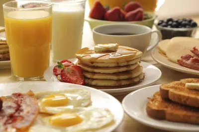 a table topped with plates of breakfast foods and drinks at Ayres Suites Mission Viejo - Lake Forest in Mission Viejo