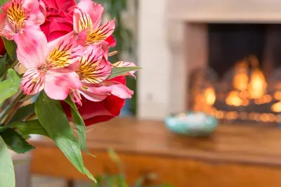 a bouquet of pink flowers in front of a fireplace at Ayres Hotel Laguna Woods - Aliso Viejo in Laguna Woods