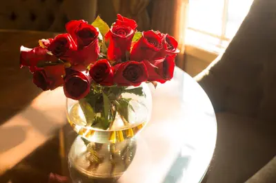 a vase filled with red roses on a table at Ayres Hotel Laguna Woods - Aliso Viejo in Laguna Woods