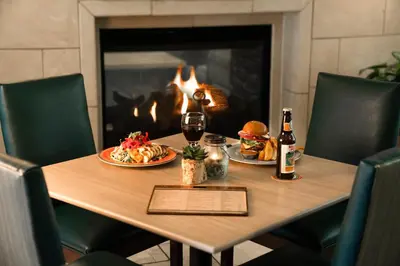 a table with two plates of food and a bottle of wine at Ayres Hotel & Spa Mission Viejo - Lake Forest in Mission Viejo