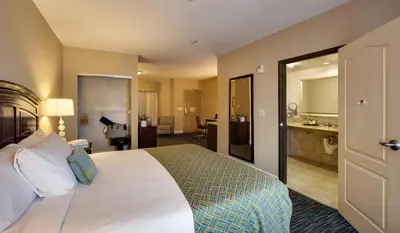 a hotel room with a large bed and a bathroom at Ayres Hotel & Spa Mission Viejo - Lake Forest in Mission Viejo