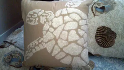 a pillow with a pattern on it sitting on a bed at 25 Steps to the Beach in Newport Beach