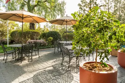 a patio with tables and chairs and umbrellas at Ayres Lodge Alpine in Alpine